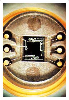 Photo 3. After anodic bonding to a Pyrex glass wafer, the individual chips are cut out of the wafer, bonded into a package such as the metal can shown here, and wire-bonded to the electrical connectors. Because Pyrex and silicon have virtually identical thermal extension coefficients, thermal tensions are eliminated by the bonding step.