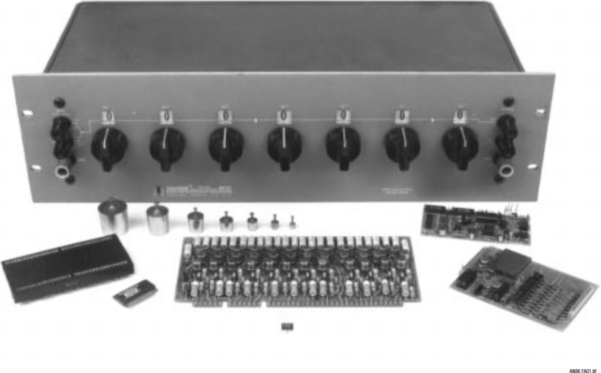 Figure A1. Historically Significant Digital-to-Analog Converters Include: Weight Set (Center Left), 23+ Bit Kelvin-Varley Divider (Large Box), Hybrid, Board and Modular Types, and the LTC1595 IC (Foreground). Where Will It All End?