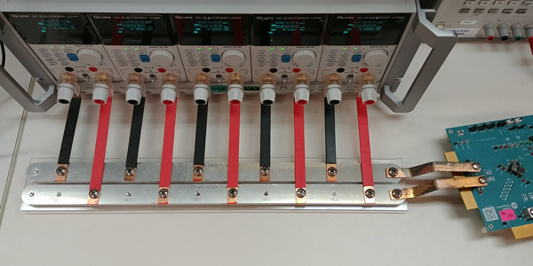 Figure 2. A parallel array of benchtop electronic loads with bus bar connections to an evaluation kit.