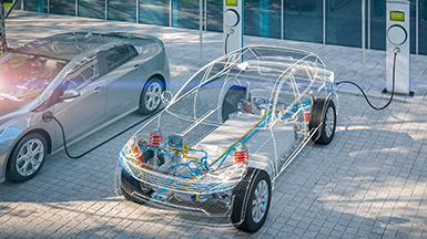 electric car with battery visible charging at public charger in a parking lot